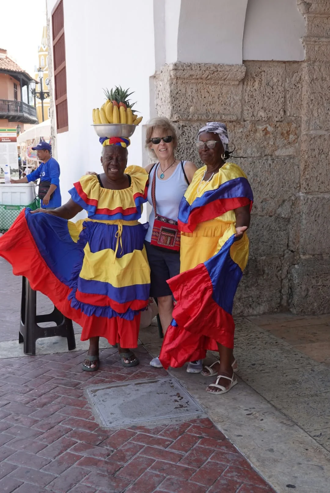 Gloria junto a dos mujeres con vestidos de colores en Cartagena de Indias.
