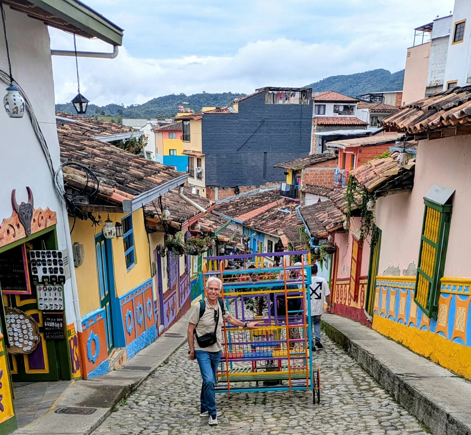 Gloria en una calle empedrada entre las fachadas de colores de Guatapé.