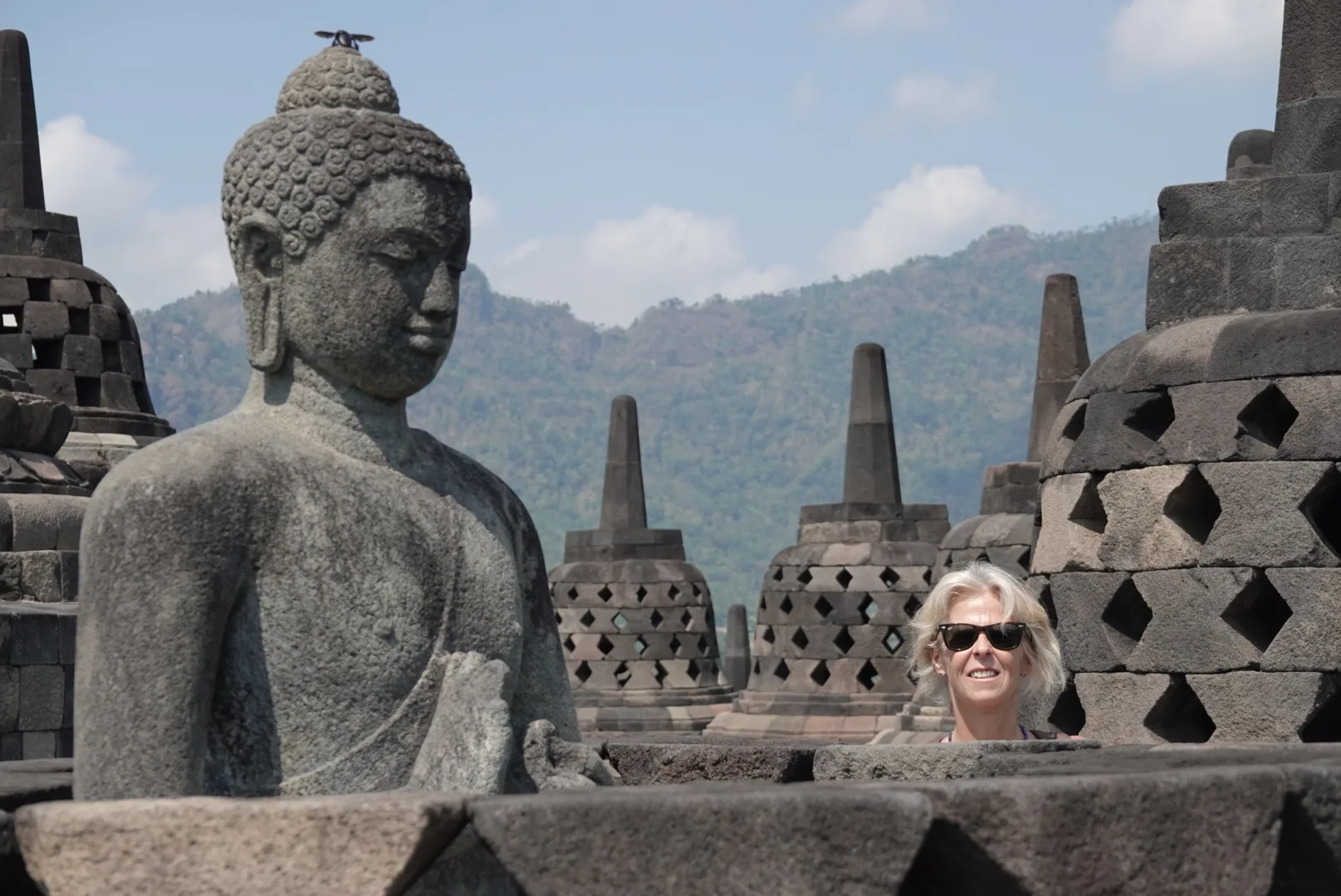 Gloria posa detrás de una estatua de Buda entre las estupas de Borobudur