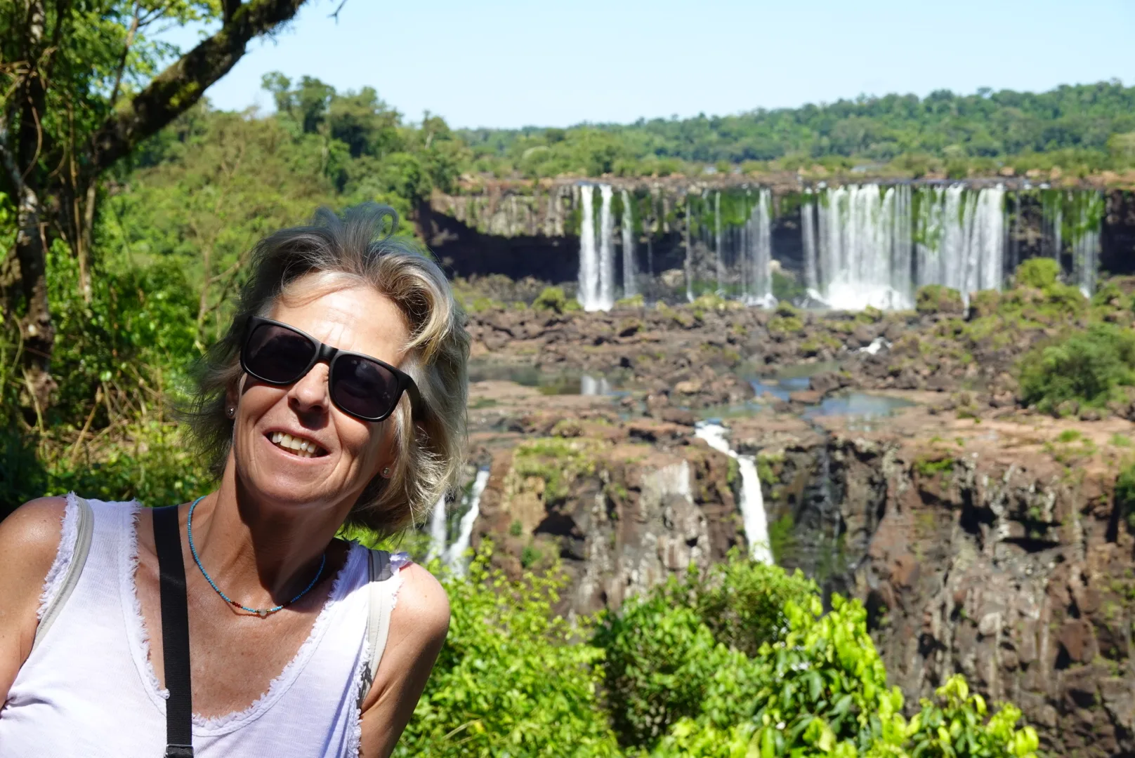 Gloria sonríe ante un paisaje de grandes cascadas rodeadas de vegetación