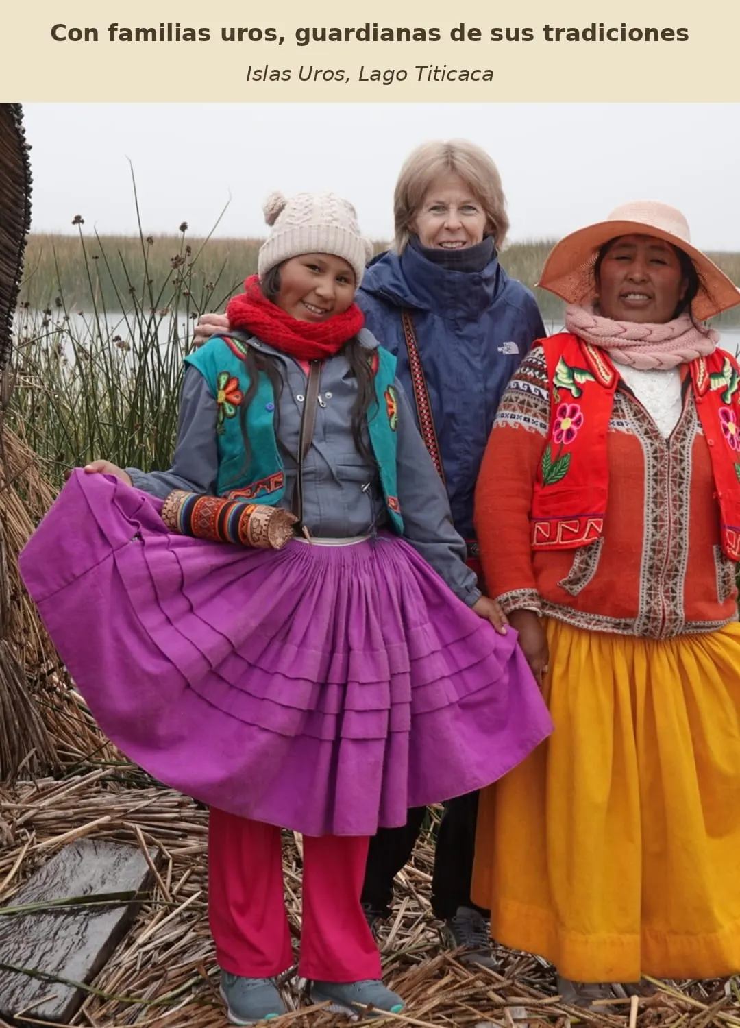 Gloria sonríe junto a dos personas de una familia Uros, rodeadas de totora y vestidos de vivos colores en el Lago Titicaca.